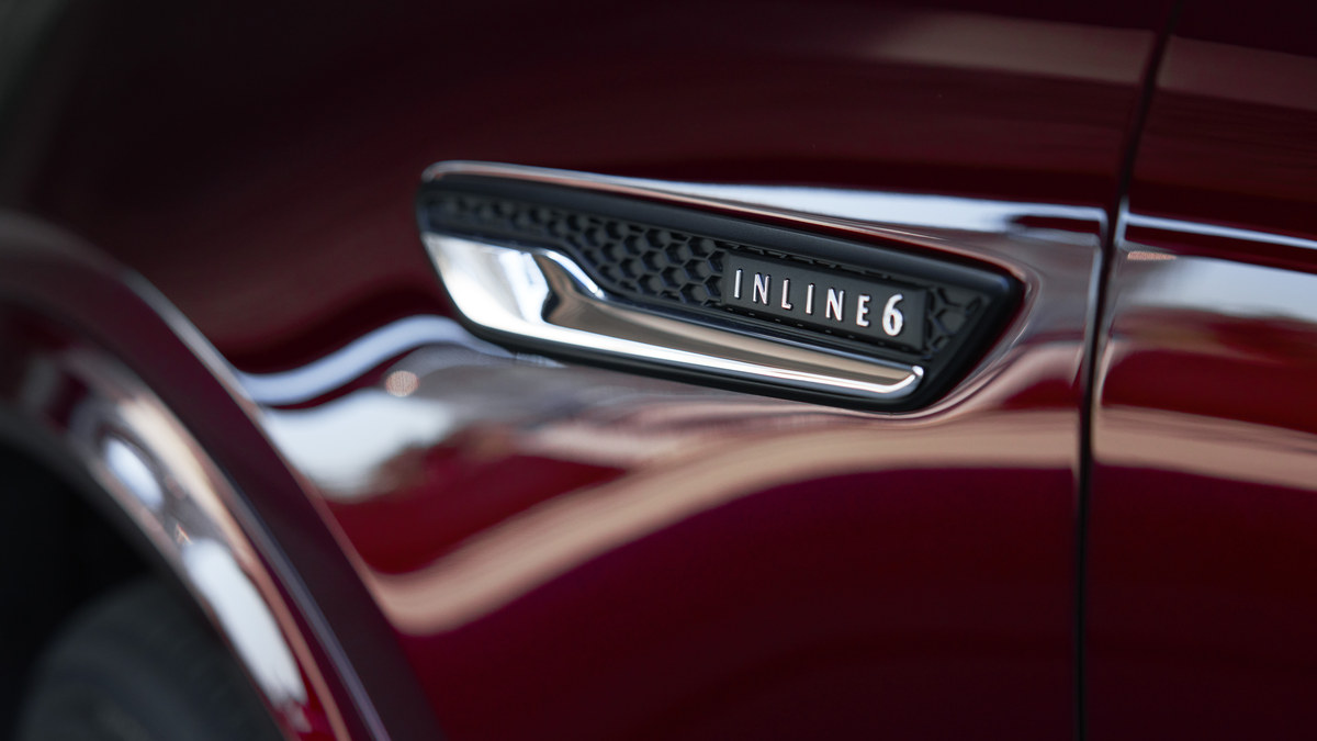 Mazda CX-90 Inline 6 badge on a dark red exterior