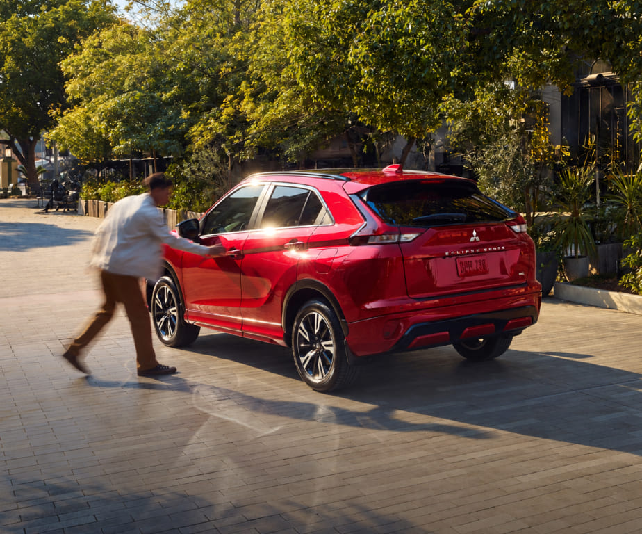 Red Mitsubishi Eclipse Cross viewed from the rear on a tree-lined street