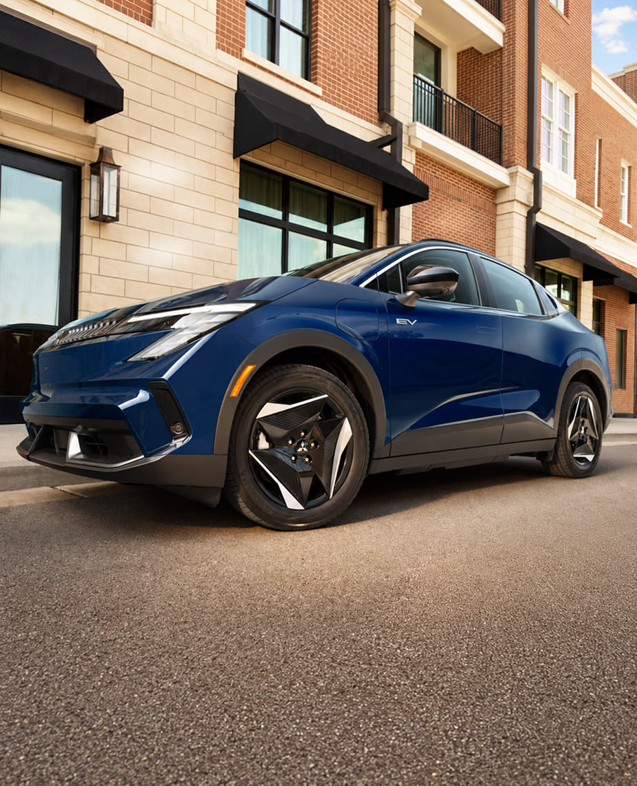 Blue 2027 Mitsubishi Eclipse Sportback EV parked beside a building