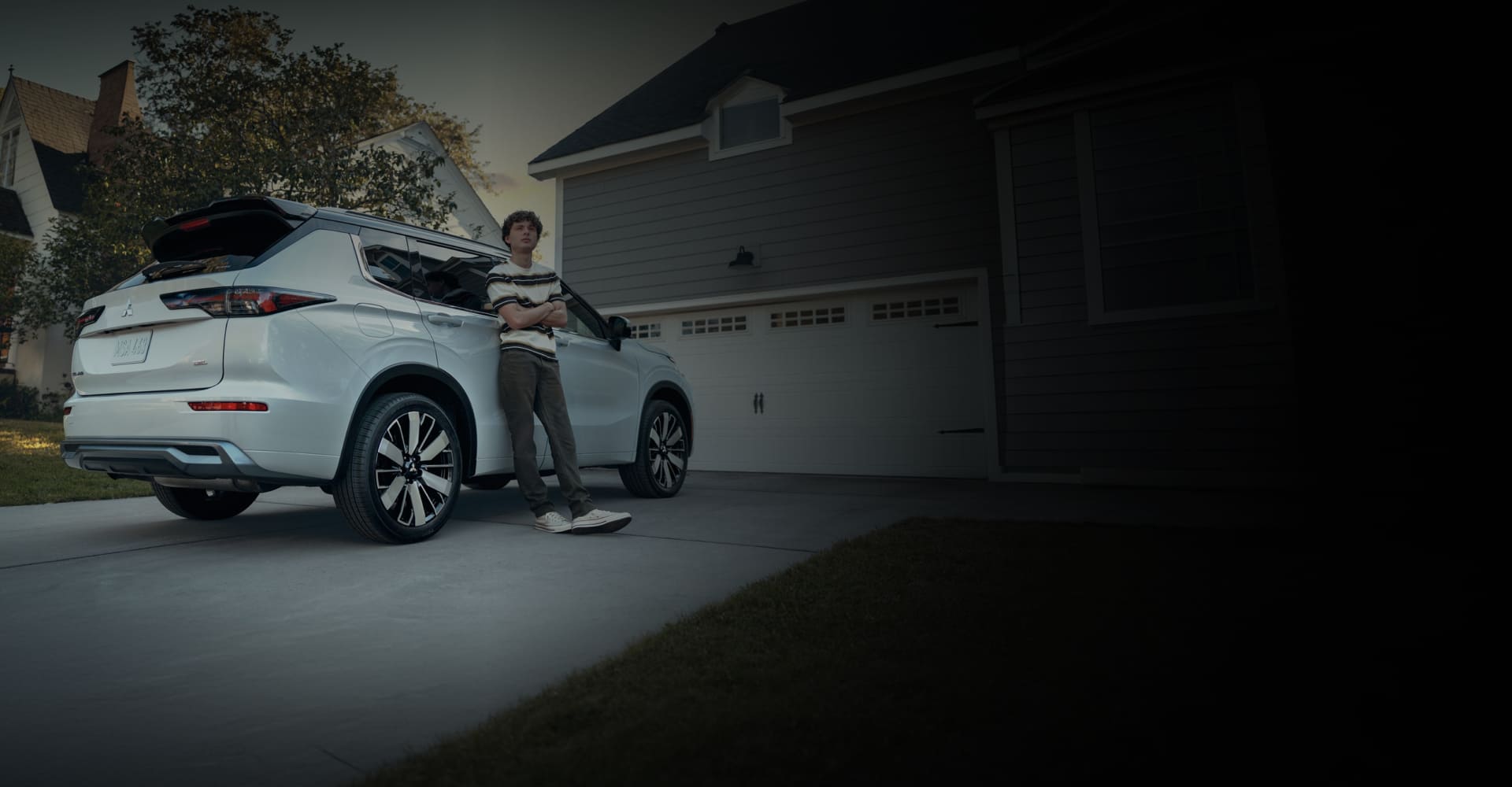 White Mitsubishi Outlander parked outside a home