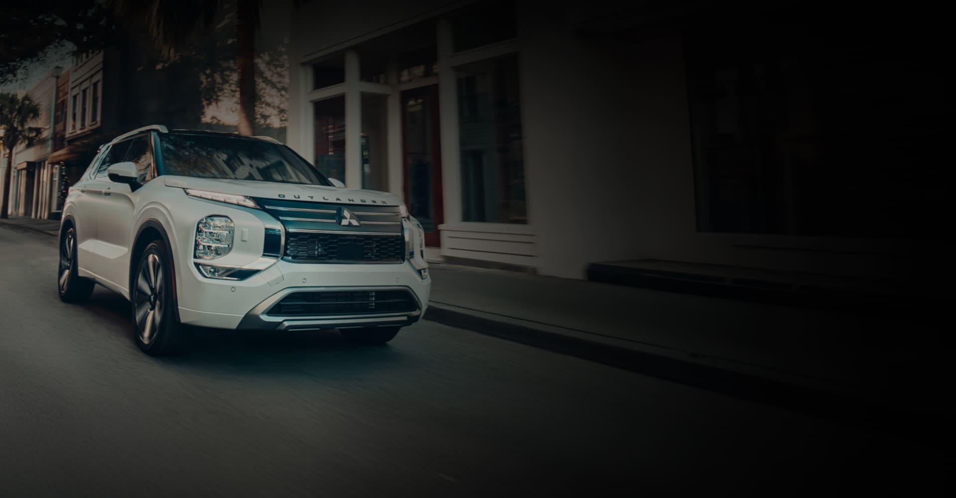 White 2026 Mitsubishi Outlander driving through a city